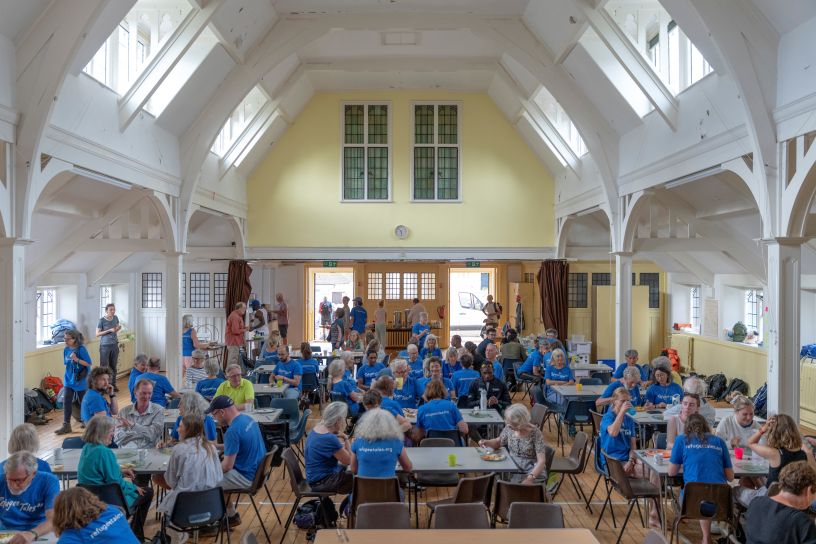 Church hall with tables and people in blue t-shirts