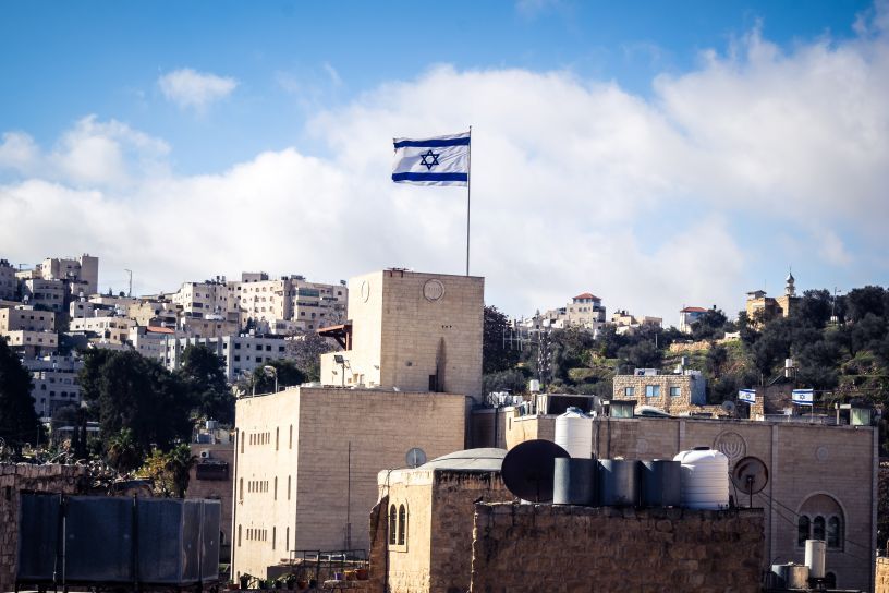 Israeli flag flying over cityscape